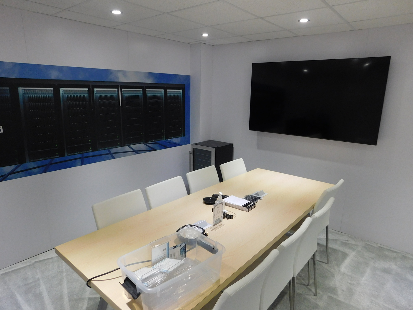 Private meeting room with a conference table and wall screen inside Marvell's OFC booth