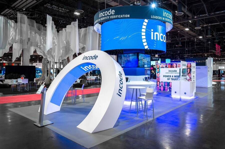 Incode's 20x40 island at Money20/20 with a curved lit arch and round LED sign