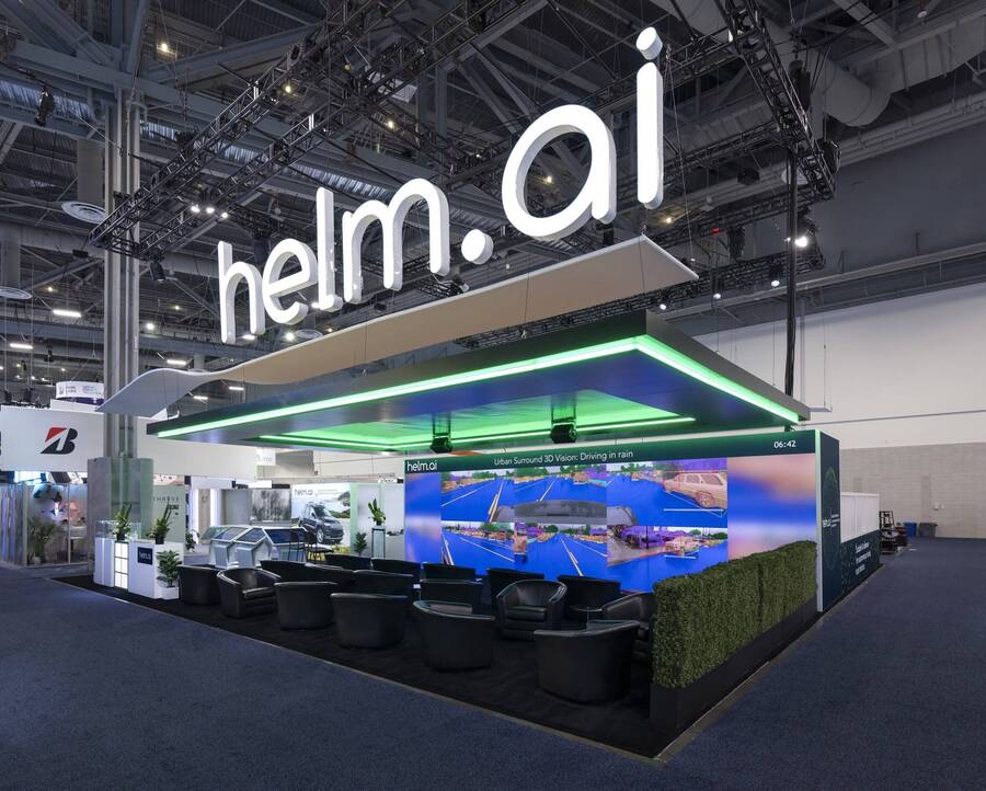 Helm.ai 50x50 island booth at CES 2024 with a lit logo canopy