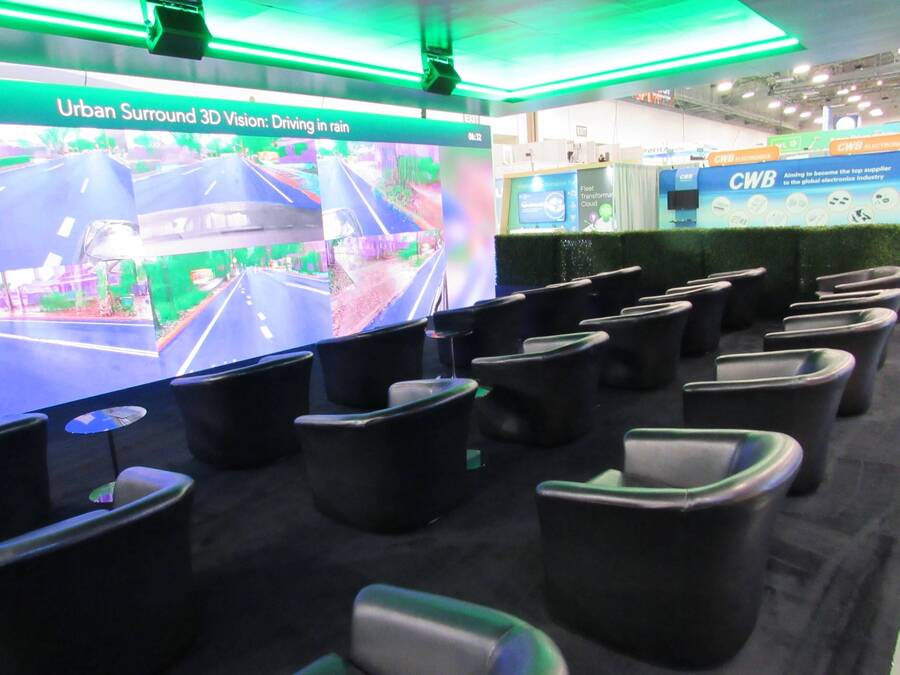 Presentation theater with lounge chairs and an LED wall in Helm.ai's CES 2024 booth