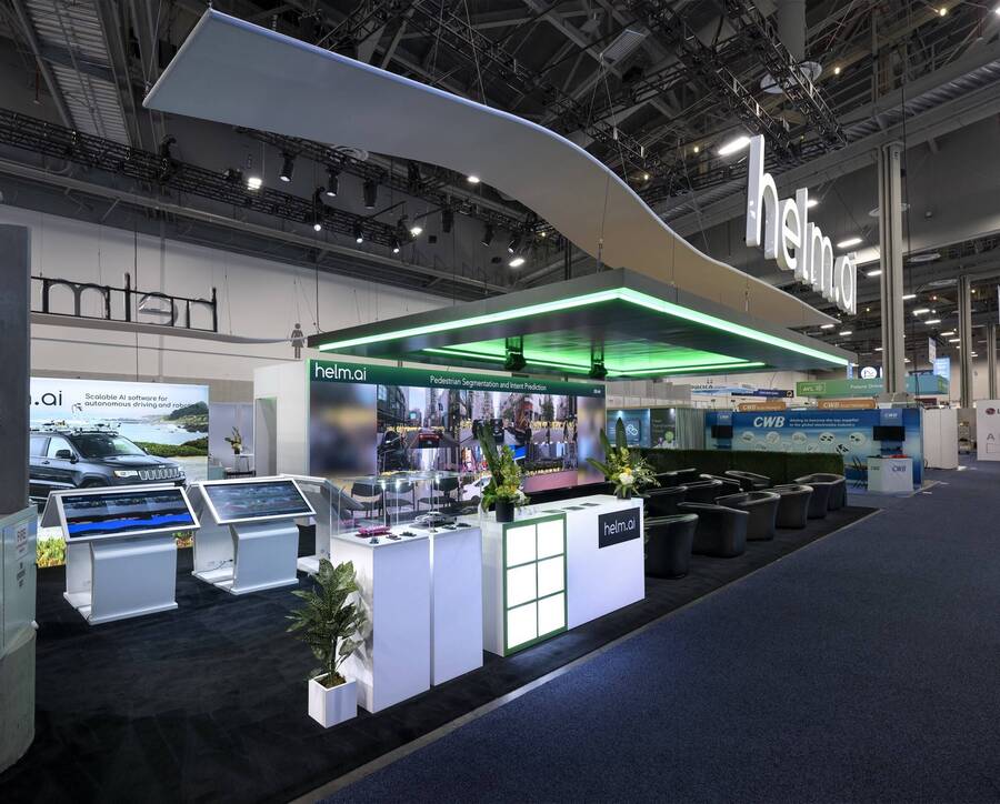 Demo kiosks under a green-lit canopy in Helm.ai's CES 2024 booth