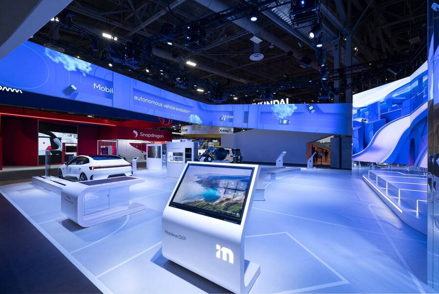 Mobileye's CES 2024 double-deck island with a demo kiosk and vehicles on the show floor