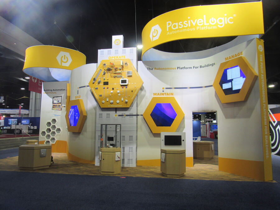 PassiveLogic's island booth at AHR Expo with yellow hexagon product displays