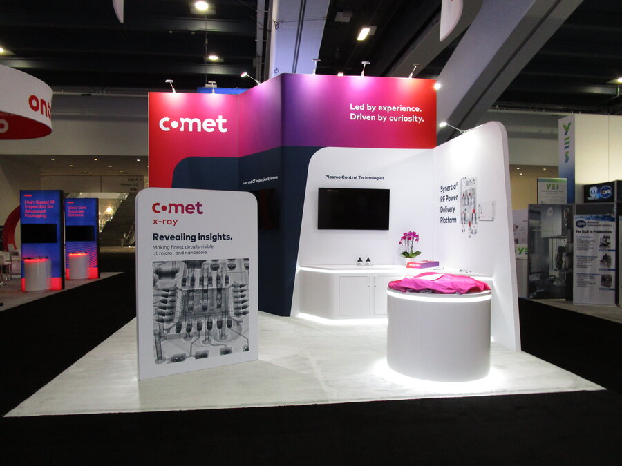 Curved white walls and a lit product pedestal in COMET's SEMICON West booth