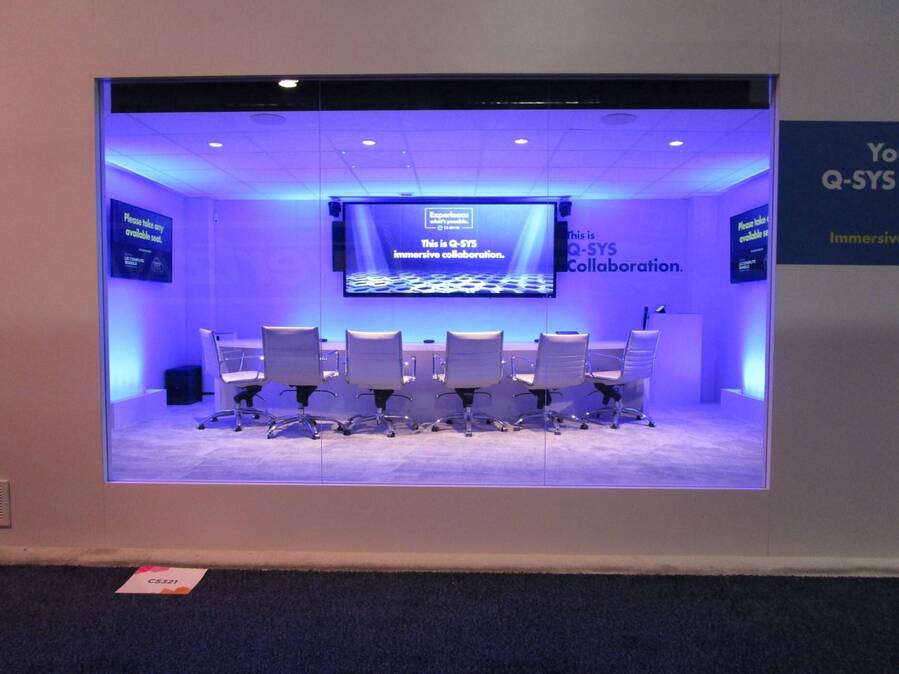 Lit conference room demo inside the Q-SYS InfoComm 2024 booth